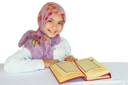 Little girl reads Quran and smiles